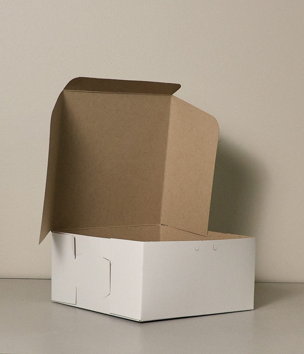 A white bakery carton with the kraft-lined lid folded open, ready to pack